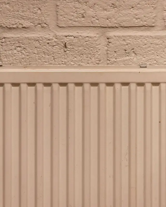 Clean white panel radiator mounted on a plastered wall