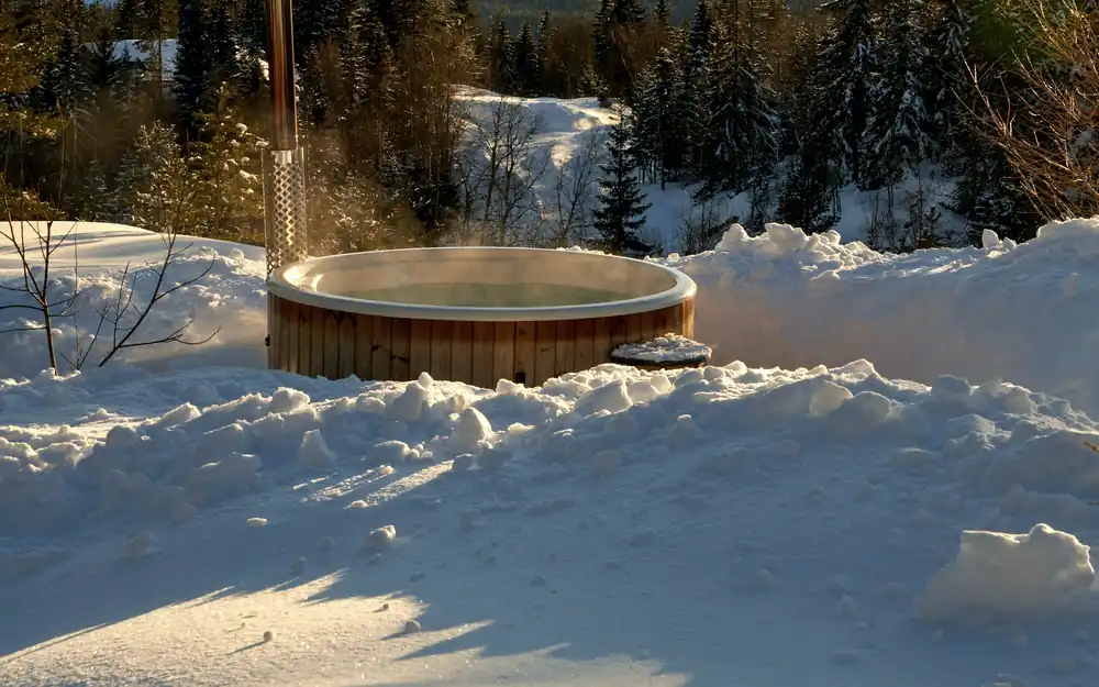 Hot tub steaming on a wooden deck backing onto North Shore forest